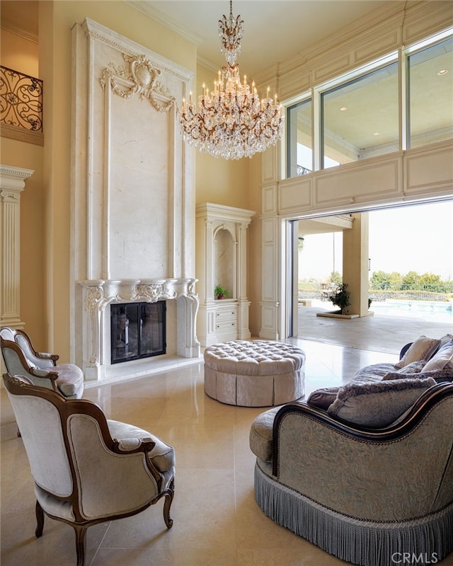 sitting room with ornamental molding, a notable chandelier, a fireplace, and a towering ceiling