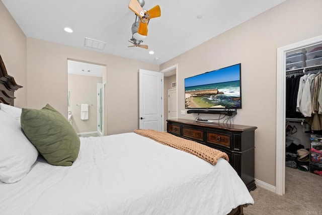 bedroom with a walk in closet, recessed lighting, a closet, light colored carpet, and baseboards