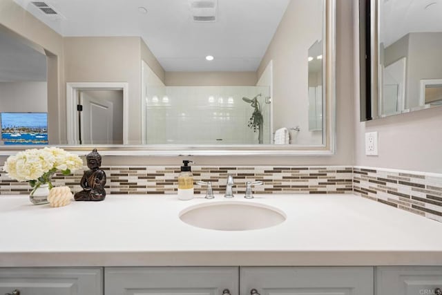 full bath with visible vents, a tile shower, and vanity