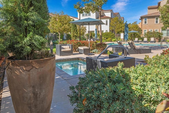 pool with a community hot tub, a patio area, and fence