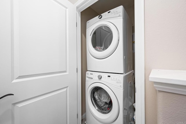 washroom with stacked washer and dryer and laundry area