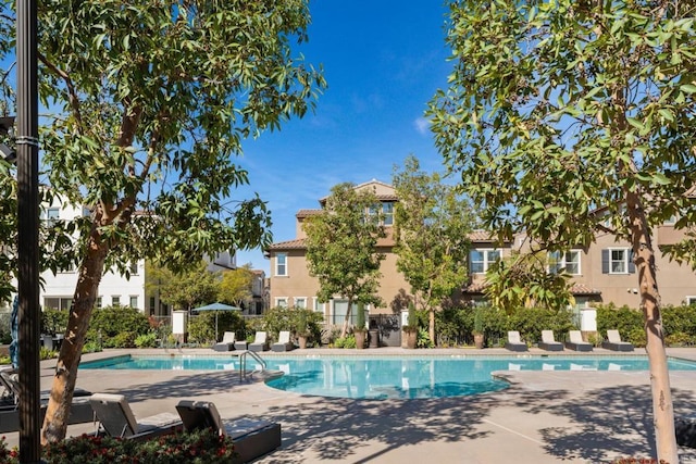 pool with a patio and fence