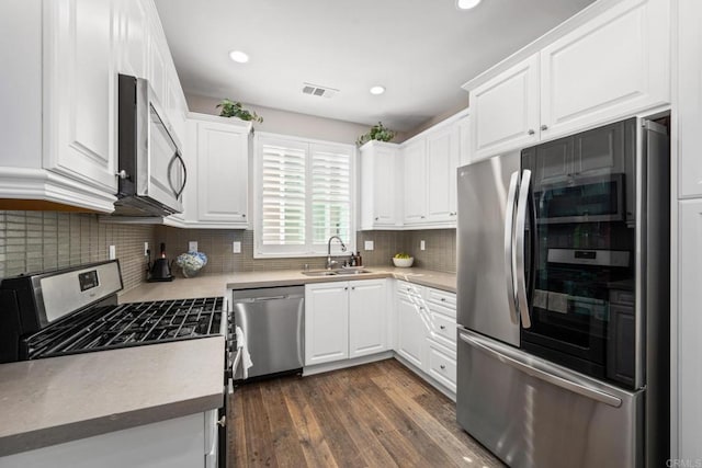 kitchen featuring stainless steel appliances, a sink, visible vents, and white cabinetry