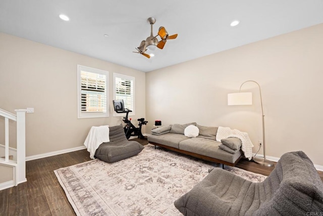 living area featuring stairway, wood finished floors, a ceiling fan, and baseboards