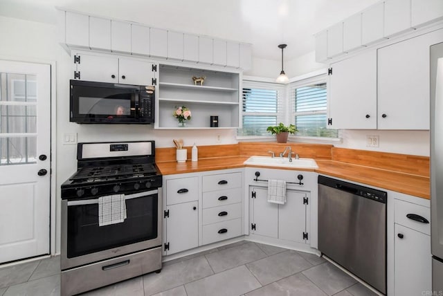 kitchen featuring stainless steel appliances, white cabinetry, and a sink