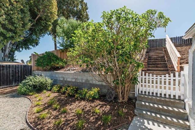 view of yard with a fenced backyard and stairs