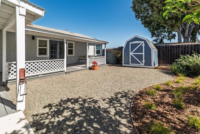 exterior space featuring an outbuilding, a patio, fence, and a shed