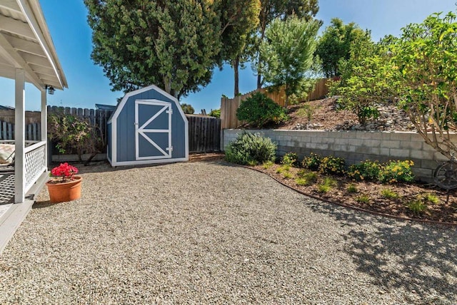 view of yard featuring a storage unit, a fenced backyard, and an outbuilding