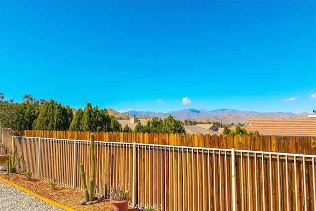 view of yard with a fenced backyard and a mountain view