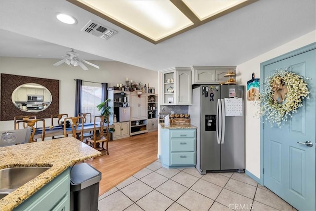 kitchen featuring visible vents, stainless steel fridge with ice dispenser, lofted ceiling, ceiling fan, and light tile patterned flooring