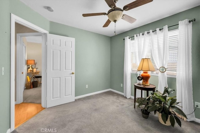 interior space with carpet floors, ceiling fan, and baseboards