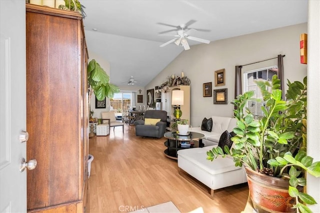 living room featuring lofted ceiling, light wood-style floors, and a ceiling fan