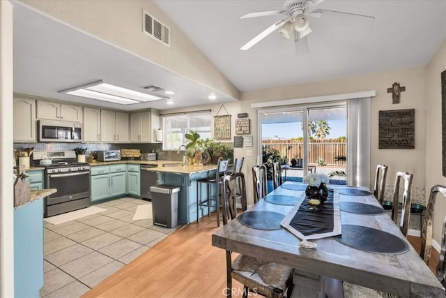 kitchen featuring vaulted ceiling, appliances with stainless steel finishes, plenty of natural light, and visible vents