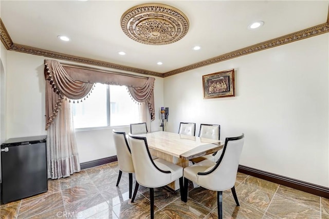 dining room with baseboards, crown molding, and recessed lighting