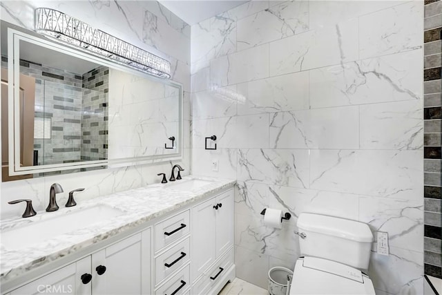 full bath with a sink, a tile shower, toilet, and double vanity