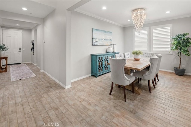 dining space featuring baseboards, light wood-style flooring, ornamental molding, an inviting chandelier, and recessed lighting