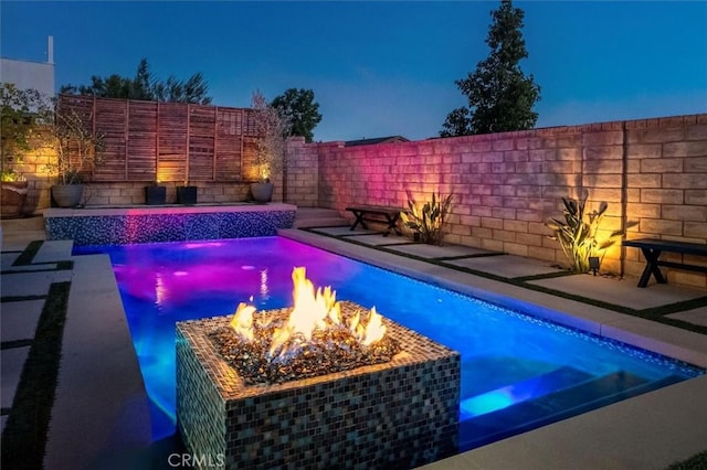 view of swimming pool featuring an outdoor fire pit, a fenced backyard, and a fenced in pool