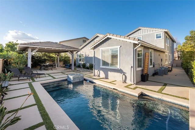 back of property featuring a patio, stucco siding, a gazebo, cooling unit, and an outdoor pool