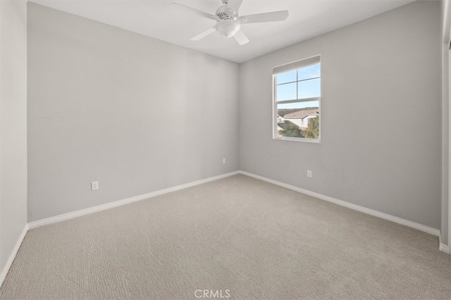 spare room featuring carpet floors, ceiling fan, and baseboards