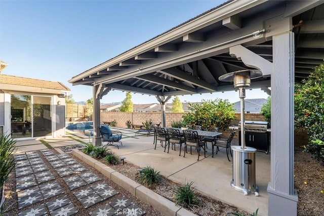 view of patio with outdoor dining space, fence, and a grill