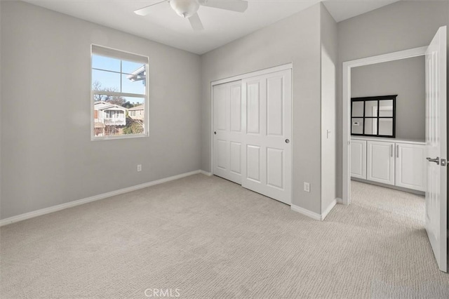 unfurnished bedroom with baseboards, a closet, a ceiling fan, and light colored carpet