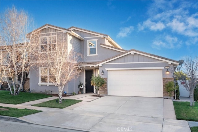 view of front facade with an attached garage, stone siding, a front lawn, and concrete driveway