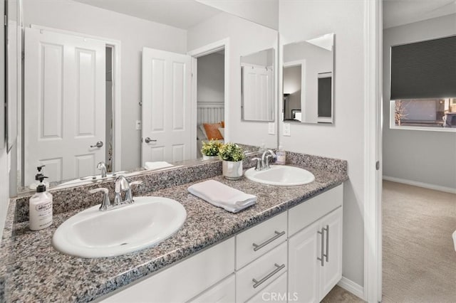 bathroom featuring a sink, baseboards, and double vanity