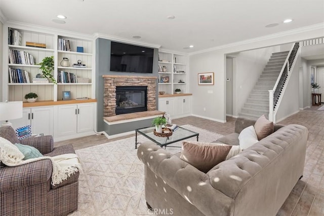 living area featuring light wood-style flooring, a fireplace, ornamental molding, and stairs