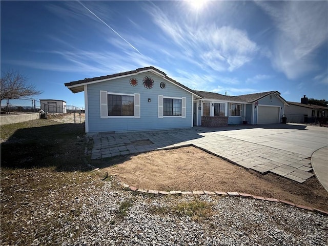 view of front of house with driveway, an attached garage, and fence