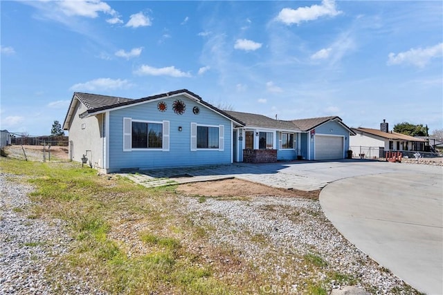 ranch-style house featuring driveway, an attached garage, and fence