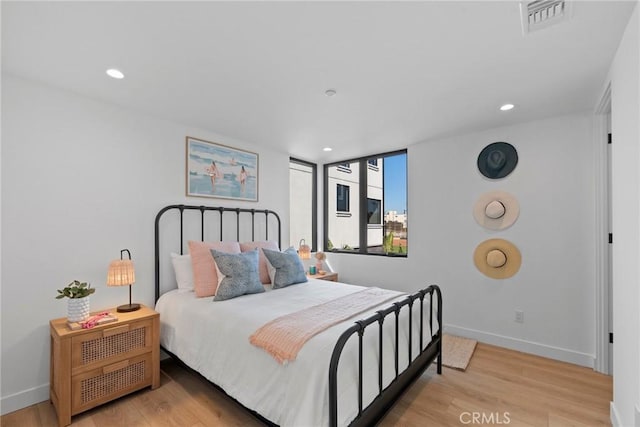 bedroom featuring baseboards, wood finished floors, visible vents, and recessed lighting