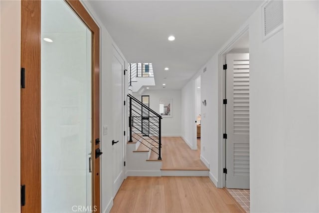 entrance foyer featuring light wood finished floors, recessed lighting, visible vents, baseboards, and stairs