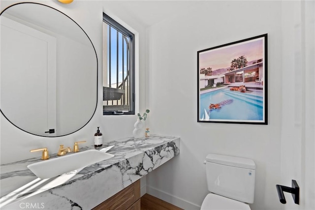 bathroom with baseboards, a sink, and toilet