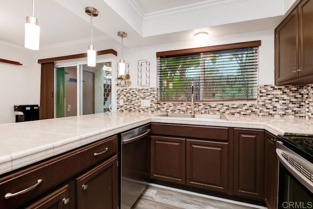 kitchen with a sink, dark brown cabinetry, appliances with stainless steel finishes, crown molding, and tasteful backsplash