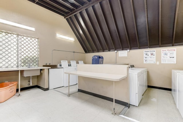 shared laundry area with a sink, light floors, independent washer and dryer, and baseboards