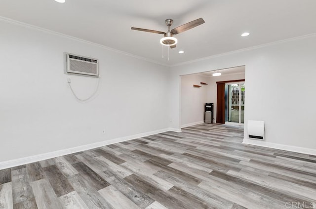 unfurnished room with recessed lighting, an AC wall unit, baseboards, and wood finished floors