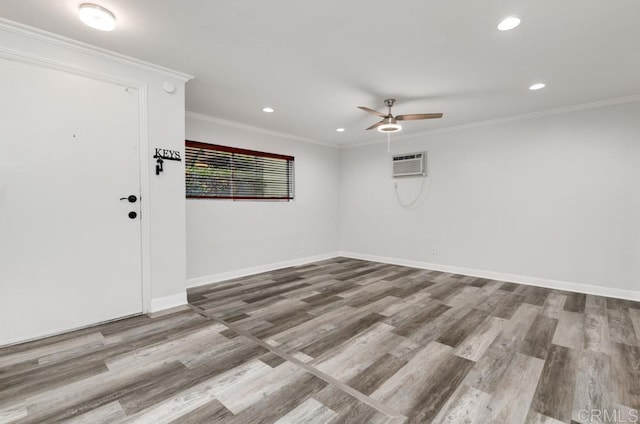 spare room with crown molding, wood finished floors, and baseboards