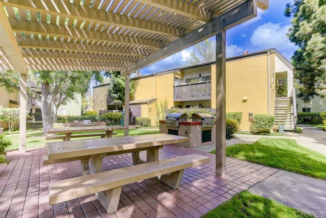 view of patio with a pergola, exterior kitchen, area for grilling, and stairway