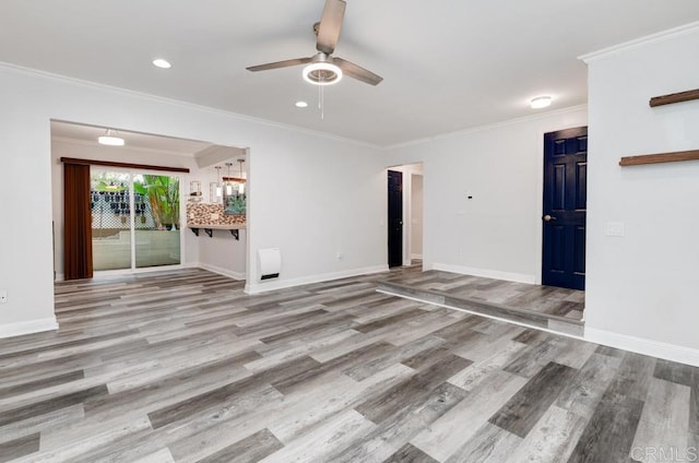 unfurnished living room featuring ceiling fan, baseboards, ornamental molding, and wood finished floors