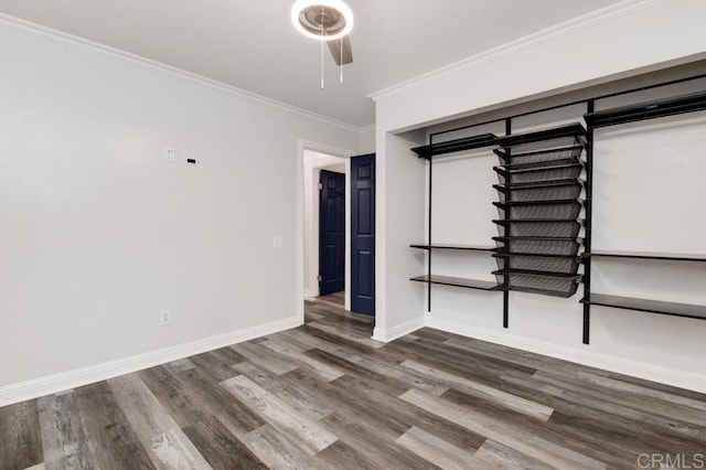 empty room featuring ceiling fan, baseboards, crown molding, and wood finished floors