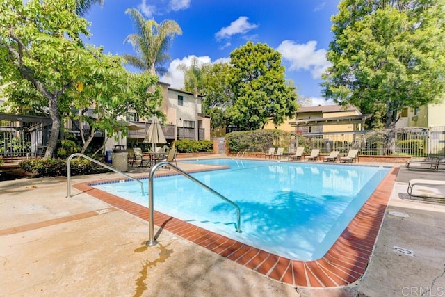 pool featuring fence and a patio