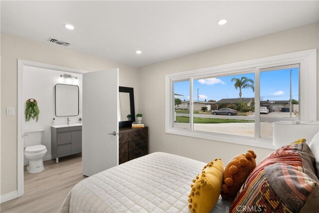 bedroom featuring visible vents, ensuite bath, wood finished floors, recessed lighting, and baseboards