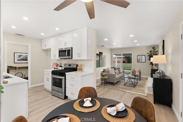 kitchen with visible vents, light countertops, light wood-style flooring, stainless steel appliances, and white cabinetry