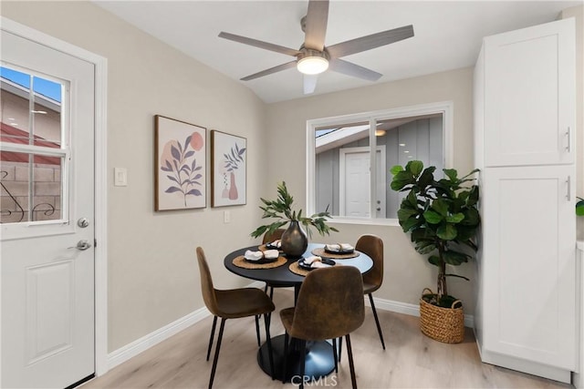 dining room with light wood-style flooring, a ceiling fan, and baseboards