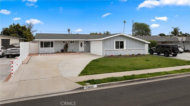 single story home with board and batten siding, a front yard, driveway, stone siding, and an attached garage