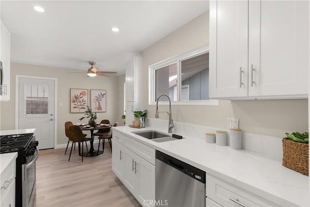 kitchen with a sink, stainless steel appliances, and white cabinets