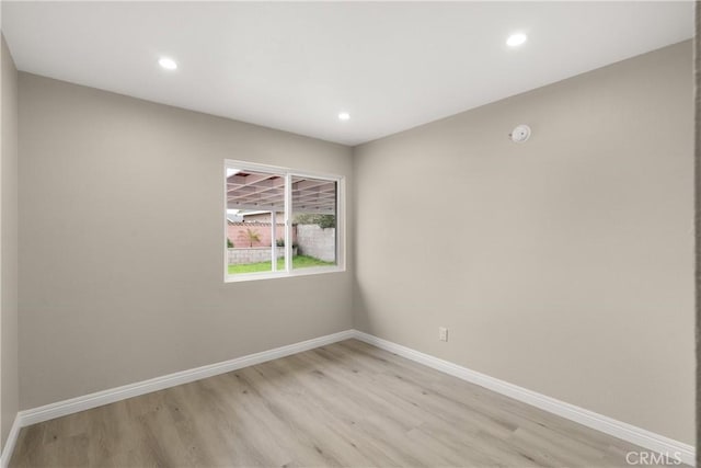 unfurnished room featuring light wood finished floors, recessed lighting, and baseboards