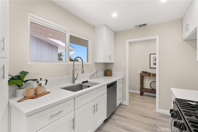 kitchen featuring visible vents, light countertops, stainless steel appliances, white cabinetry, and a sink