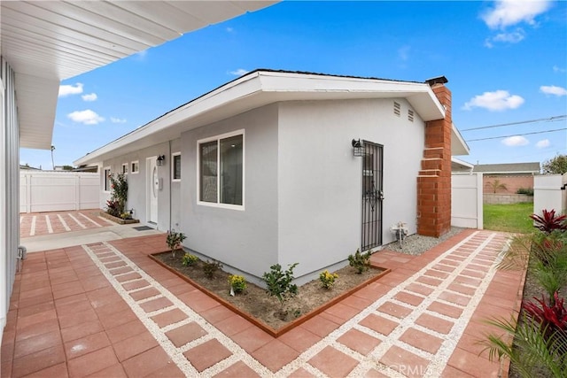 view of home's exterior featuring a patio area, stucco siding, and fence