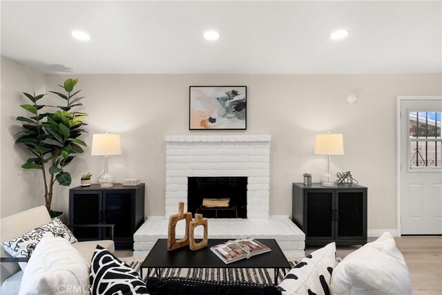 living room with recessed lighting, baseboards, wood finished floors, and a fireplace